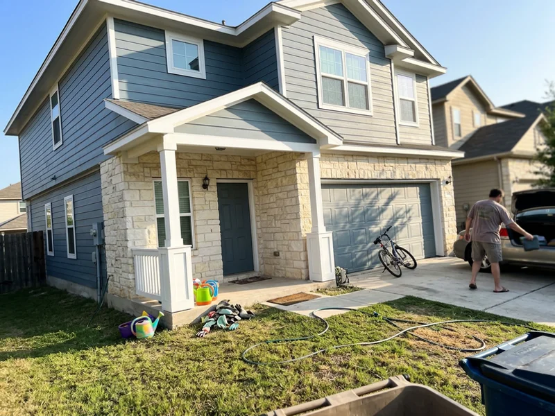 Freshly repainted two-story Round Rock house with crisp trim around a limestone front