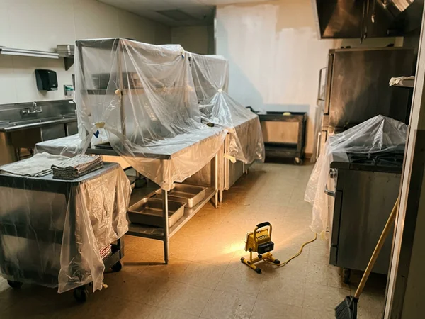 Restaurant prep area with equipment covered during painting