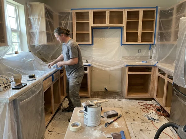 Round Rock kitchen masked in plastic with cabinet boxes ready for primer